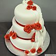 3 tier white wedding cake with red roses