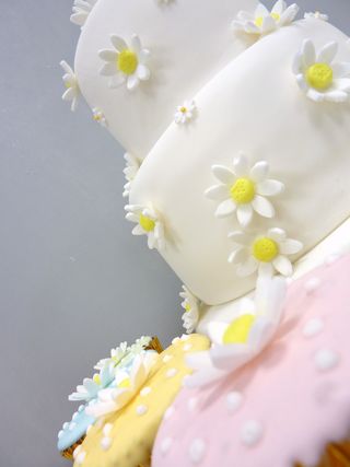 2 tier wedding cake with pastel cup cakes