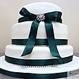 La Creme 3 tier ivory wedding cake with green ribbon and diamantes