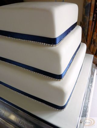 3 tier ivory wedding cake with blue ribbons and diamantees S